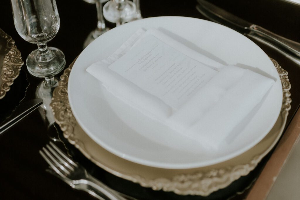 Luxurious wedding table setting with fine dining cutlery and crystal glasses.